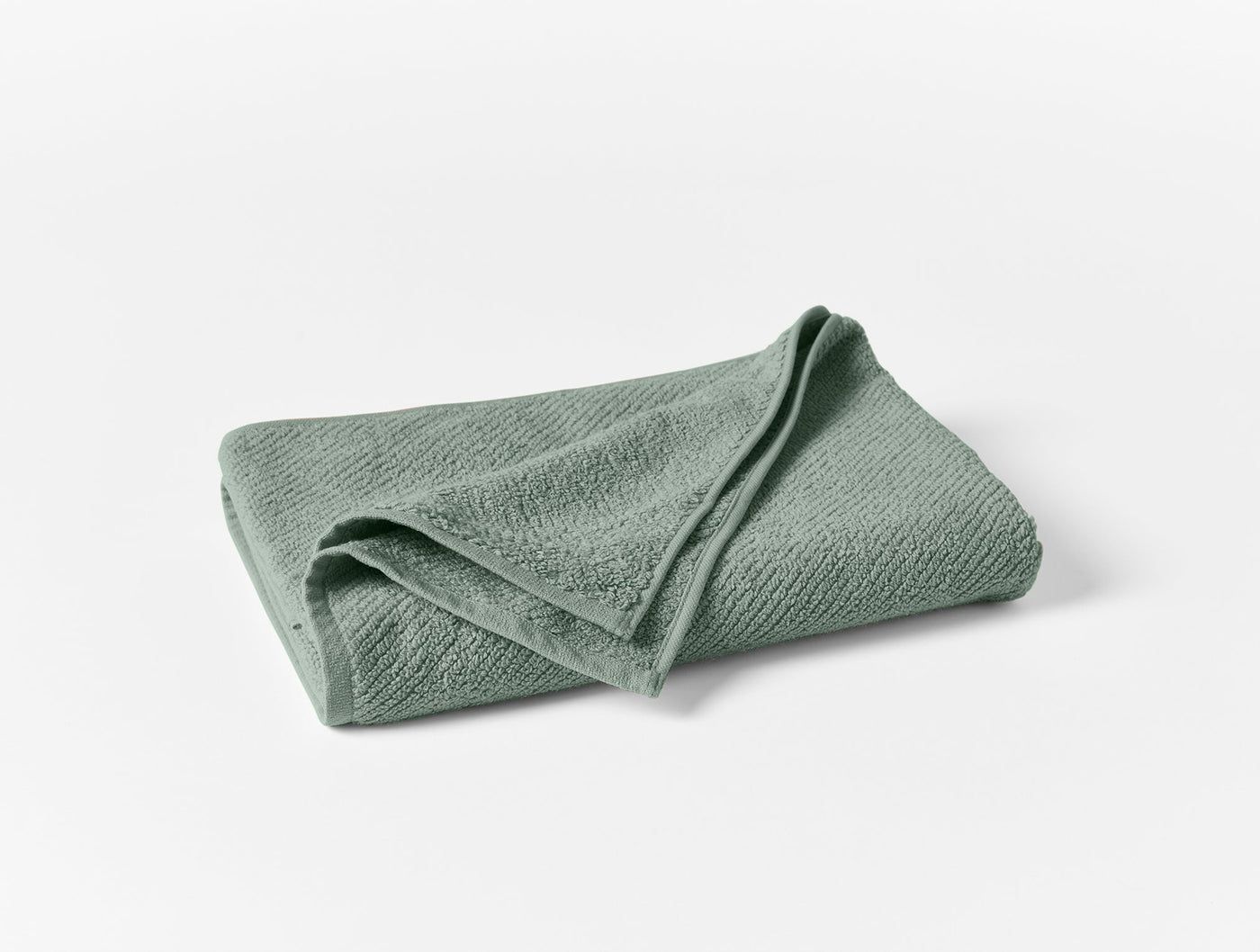 Coyuchi Air Weight wash cloth in sage green, folded, showing subtle woven texture.