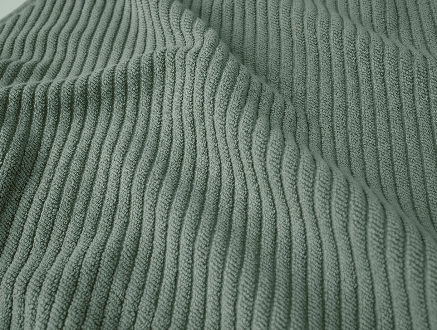 Close-up of sage green ribbed cotton weave texture on Coyuchi Air Weight bath rug.