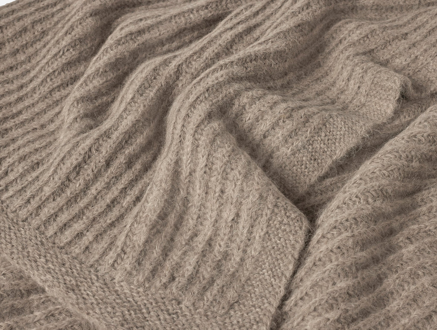 Close-up of Coyuchi Andes Suri Alpaca Knit Throw showing ribbed texture and soft drape.