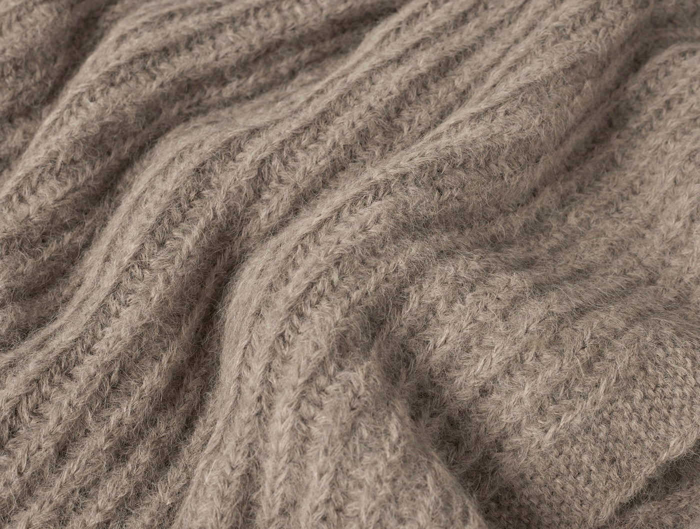 Close-up of ribbed knit weave texture in taupe alpaca throw.