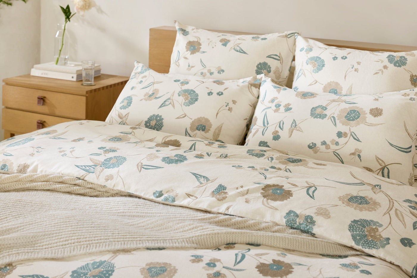 Coyuchi Aurora Print duvet cover styled on bed, ivory with blue and taupe floral print.