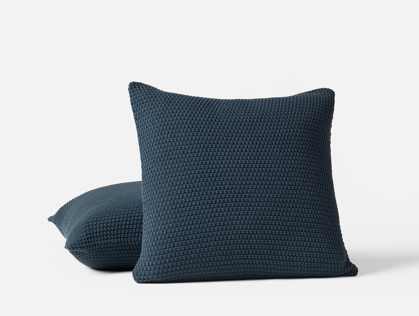 Coyuchi Avalon Knit pillow covers in navy, showing chunky knit texture, two sizes.