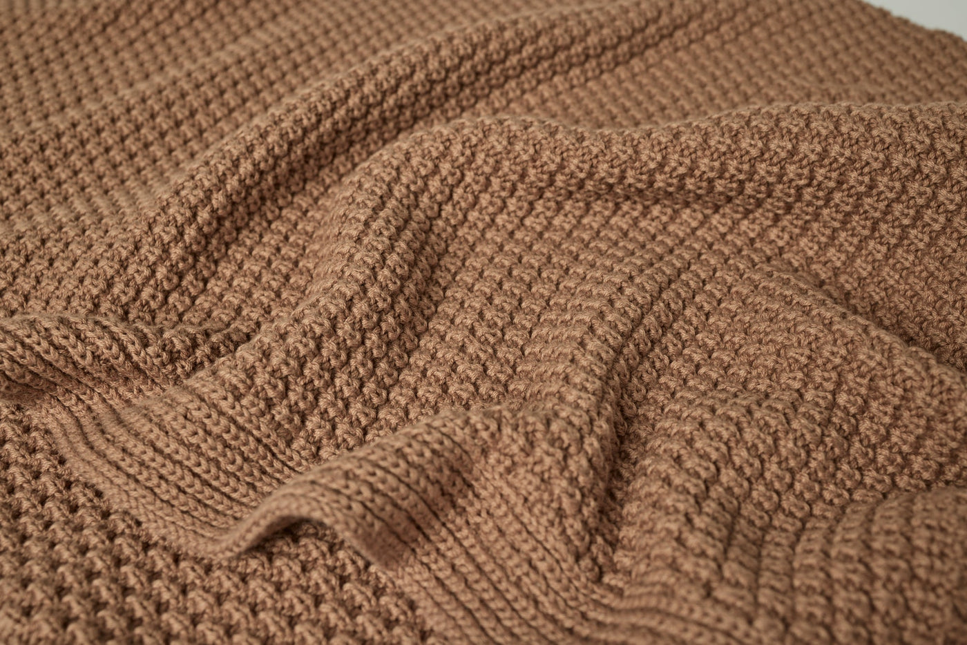 Close-up of caramel waffle-knit texture on the Avalon Throw, softly draped.