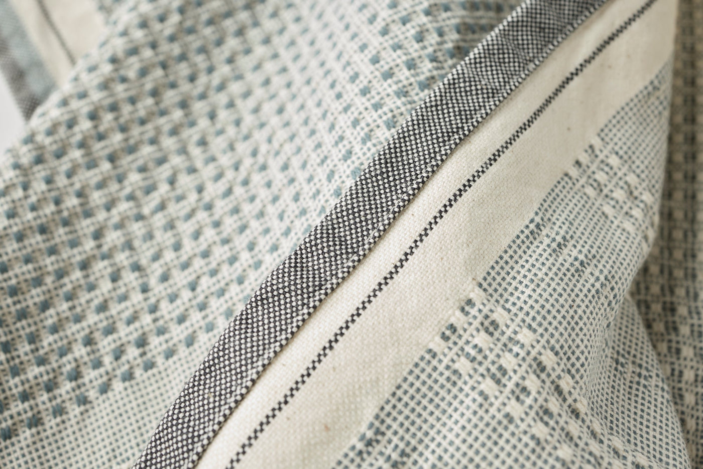 Close-up of Coyuchi Bay hand towel hem, showing woven sage and charcoal border detail.