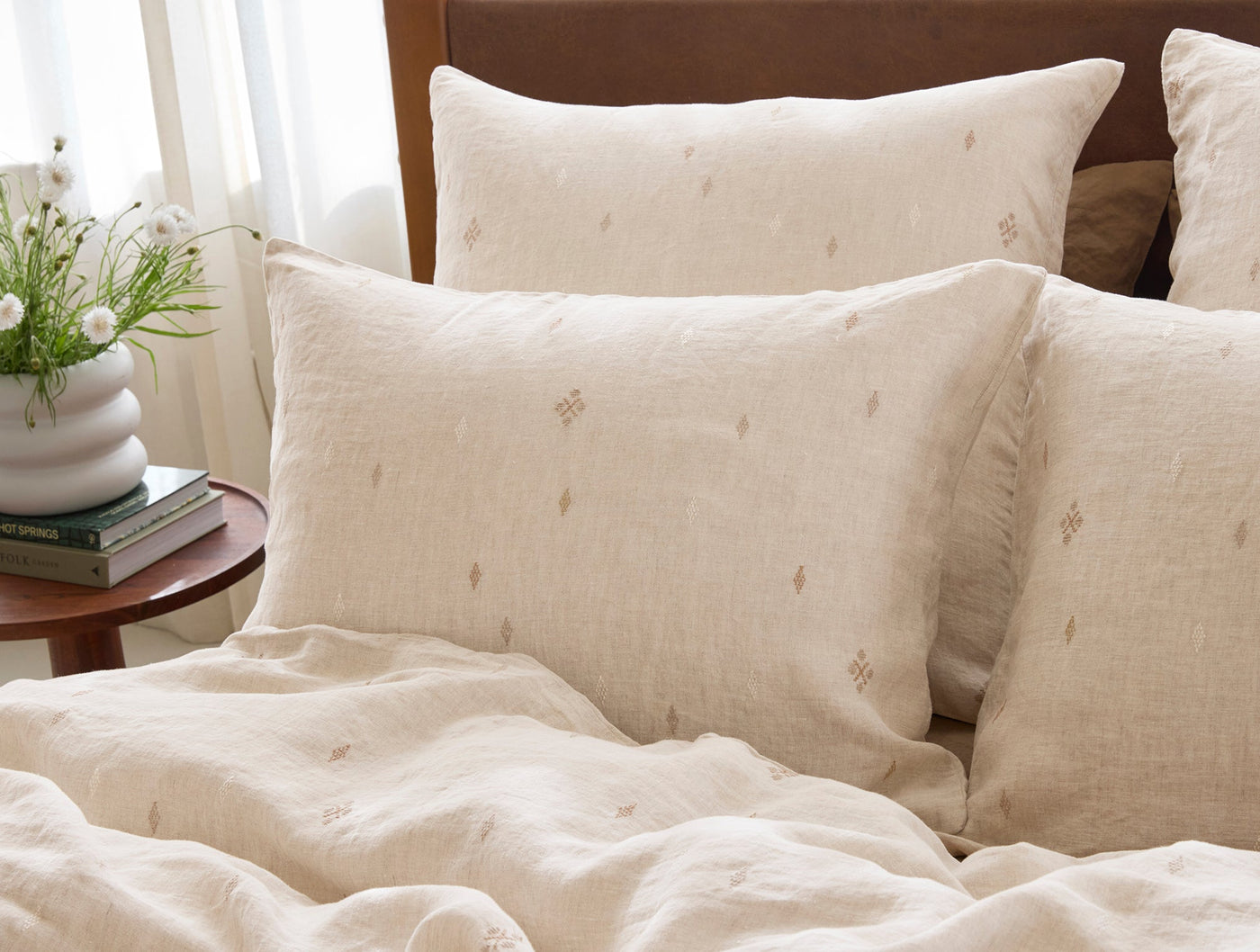 Close-up of Coyuchi Cambria sham in natural linen with tonal diamond embroidery pattern.