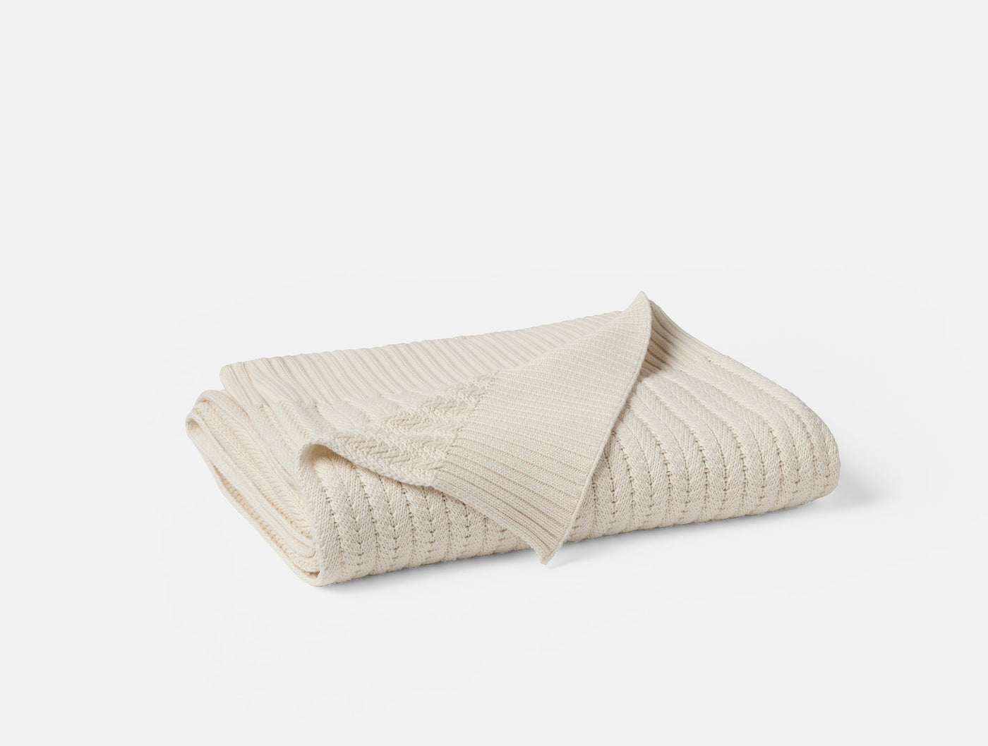 Close-up of ivory knit texture and folded edge detail on Coyuchi Casa Loma throw.