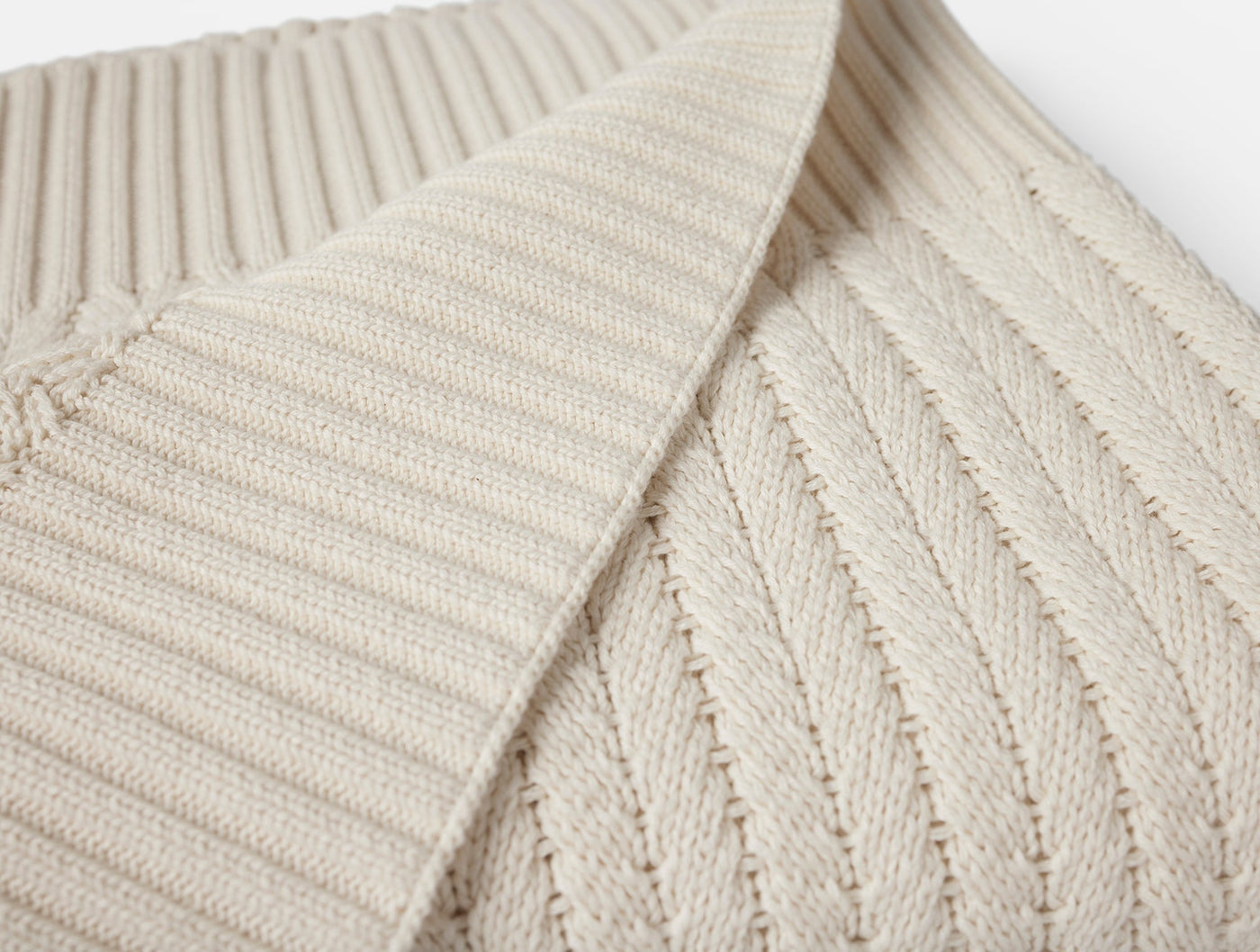 Close-up of ivory ribbed knit texture and folded edge detail on Coyuchi Casa Loma throw.