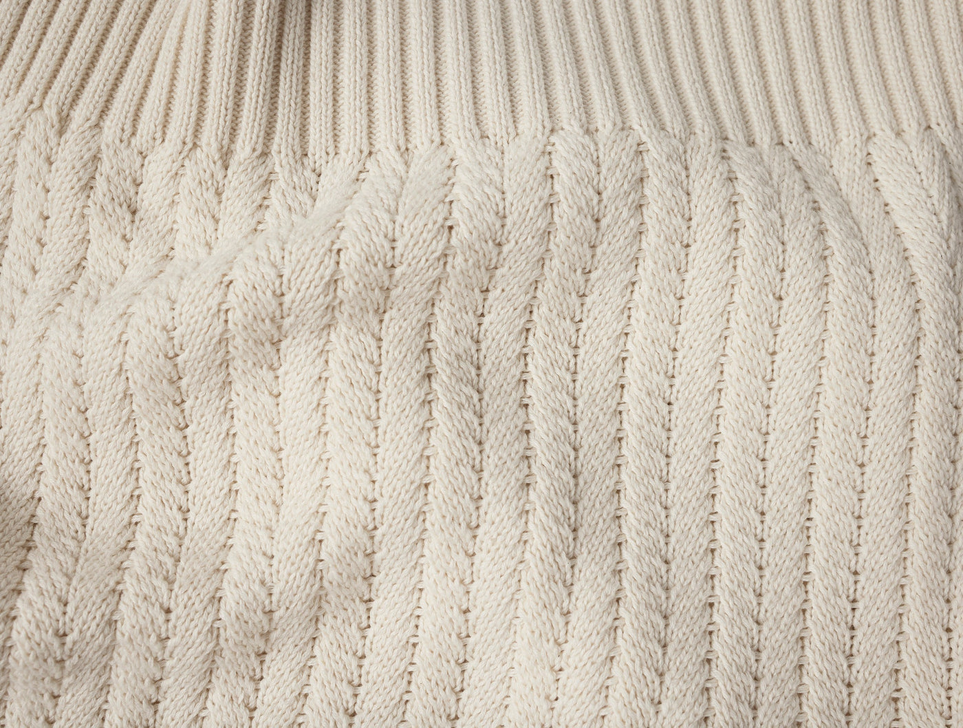 Close-up of Coyuchi Casa Loma Knit Throw in ivory, showing cable-knit texture and ribbed edge.