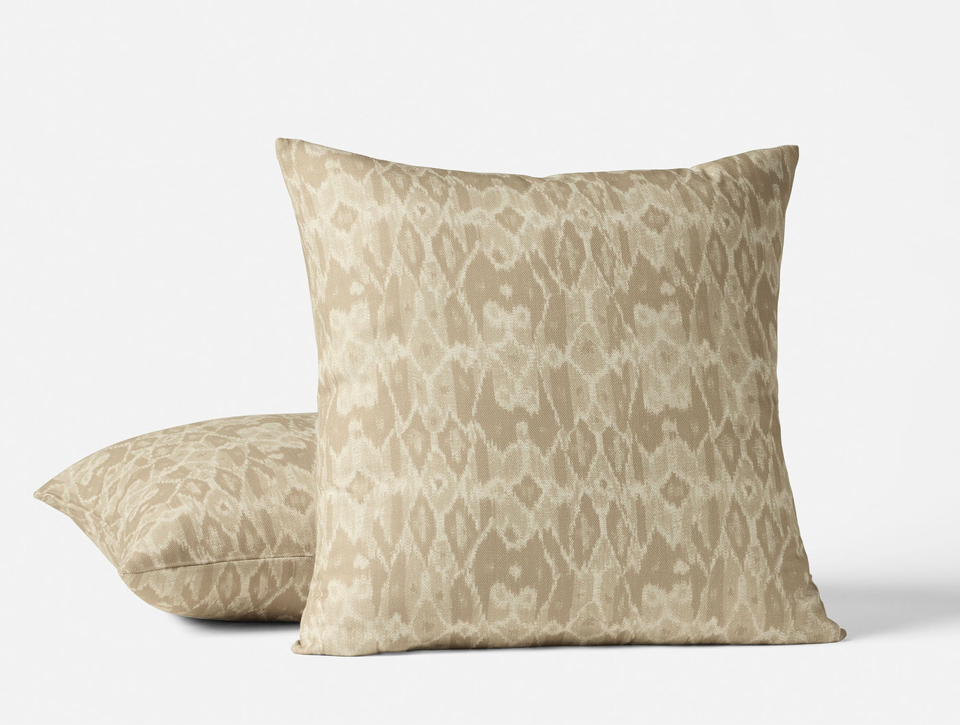 Two Coyuchi Cavallo Print pillows styled together, sand ikat pattern on linen.