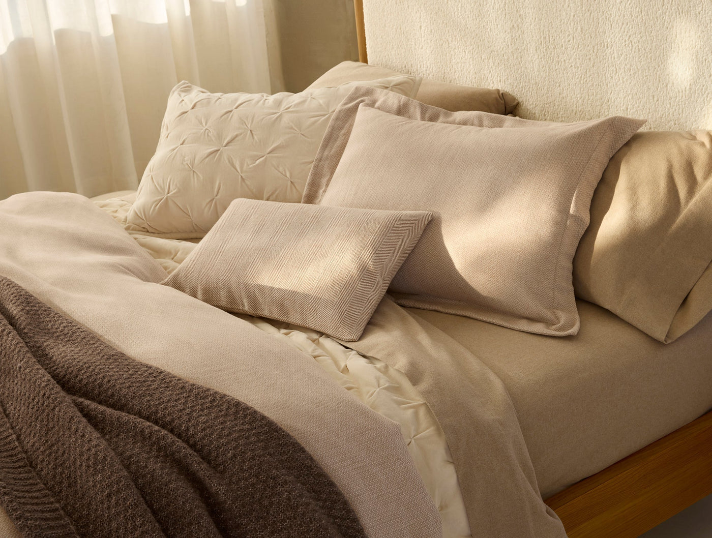 Warm sand flannel duvet cover styled on bed with layered pillows and chunky knit throw.