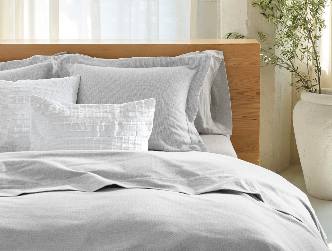Close-up of Coyuchi Cloud Brushed Flannel duvet cover in silver-grey on styled bed.