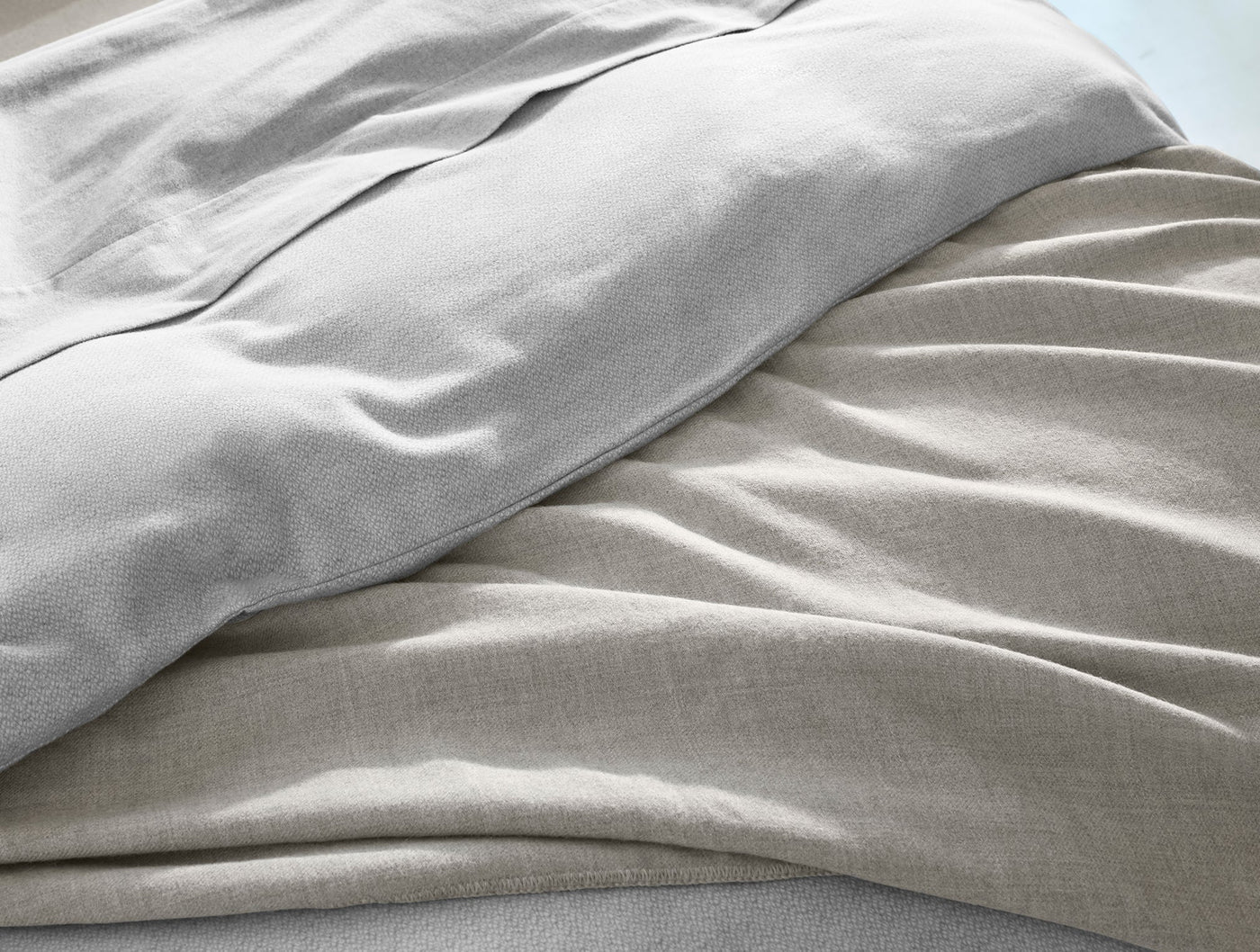 Close-up of Coyuchi Cloud Brushed Flannel sham in warm grey, showing soft napped texture with natural drape.