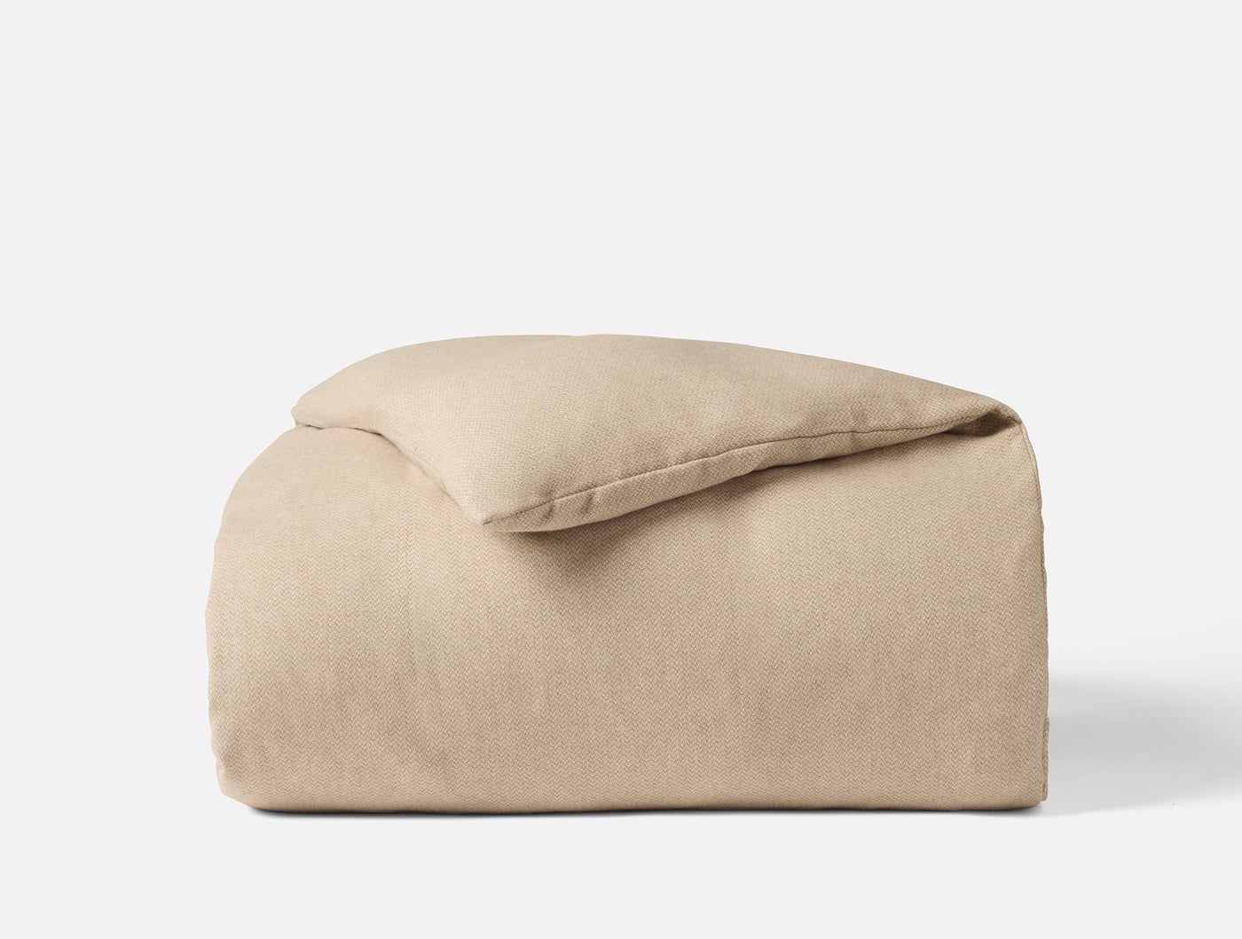 Close-up of folded oatmeal flannel duvet cover with softly brushed matte texture.