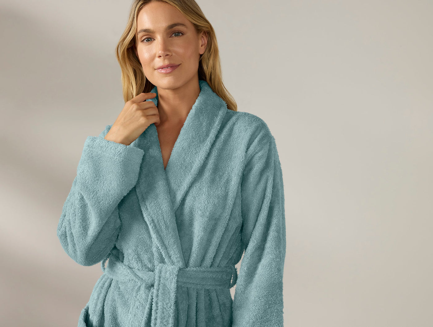 Close-up of Coyuchi Cloud Loom robe in teal, worn and belted, showing plush terry texture.