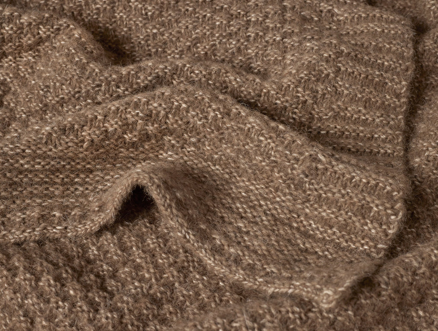 Close-up of Coyuchi Cordillera throw showing heathered mocha alpaca-cotton knit texture and drape.