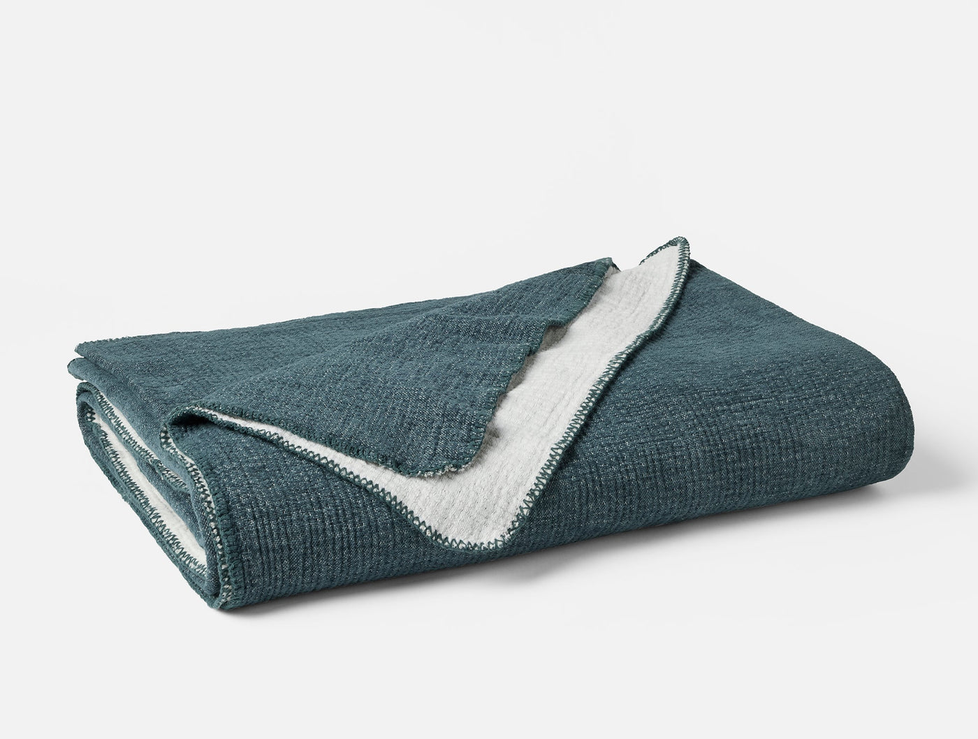 Folded teal chenille blanket with ivory reverse and crochet-style edge detail.