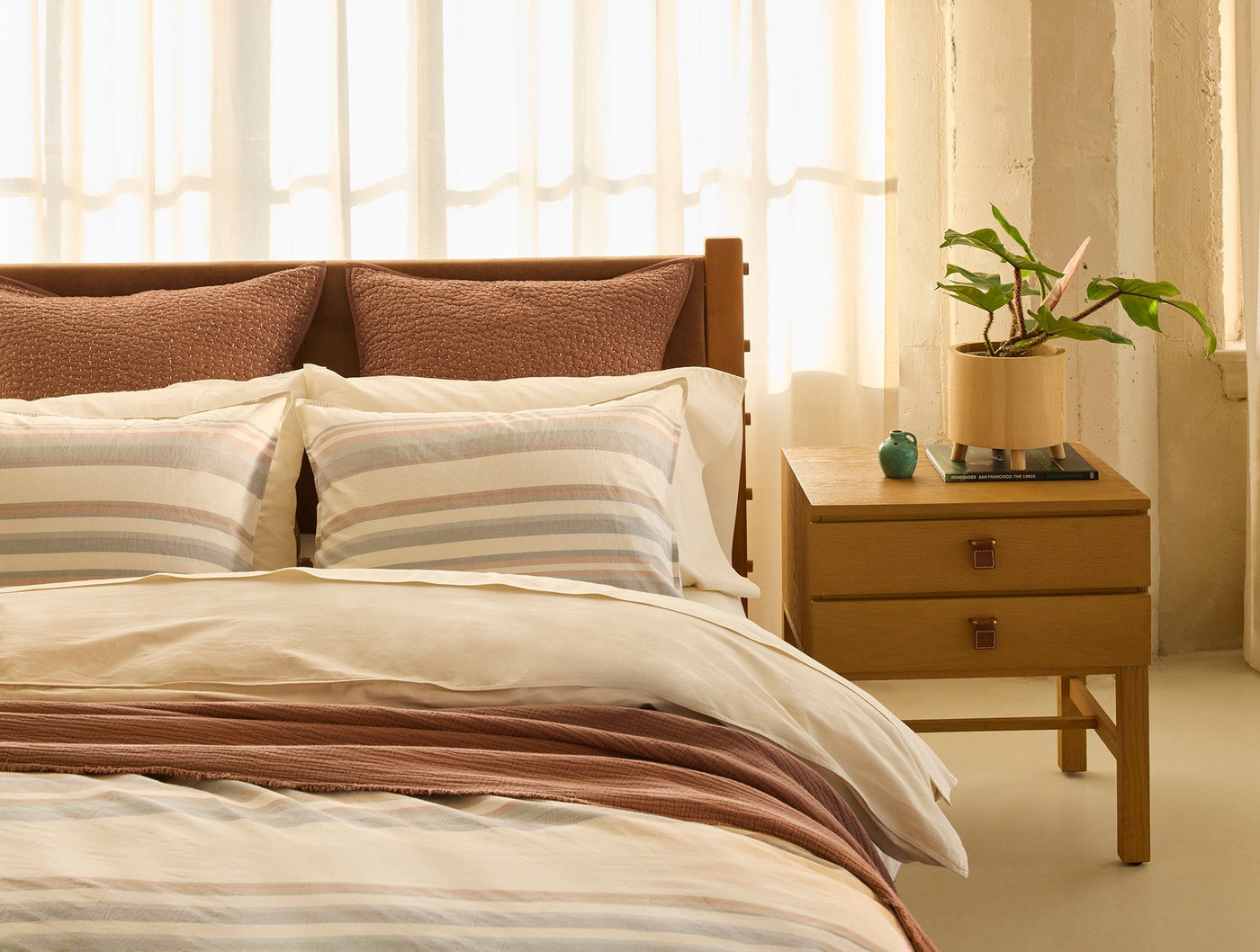 Close-up of Coyuchi Crestridge sham styled on bed with striped bedding and terracotta euro shams.
