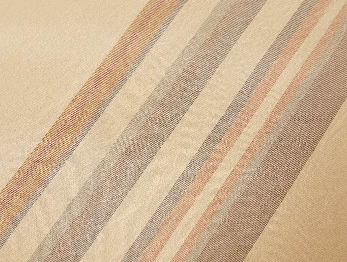 Close-up of Coyuchi Crestridge sham fabric with diagonal champagne, blush, and taupe stripes.
