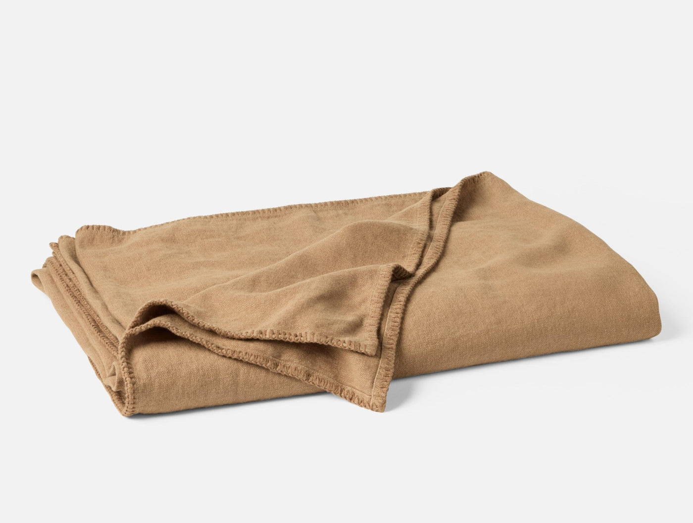 Folded camel linen blanket showing blanket stitch edge detail.