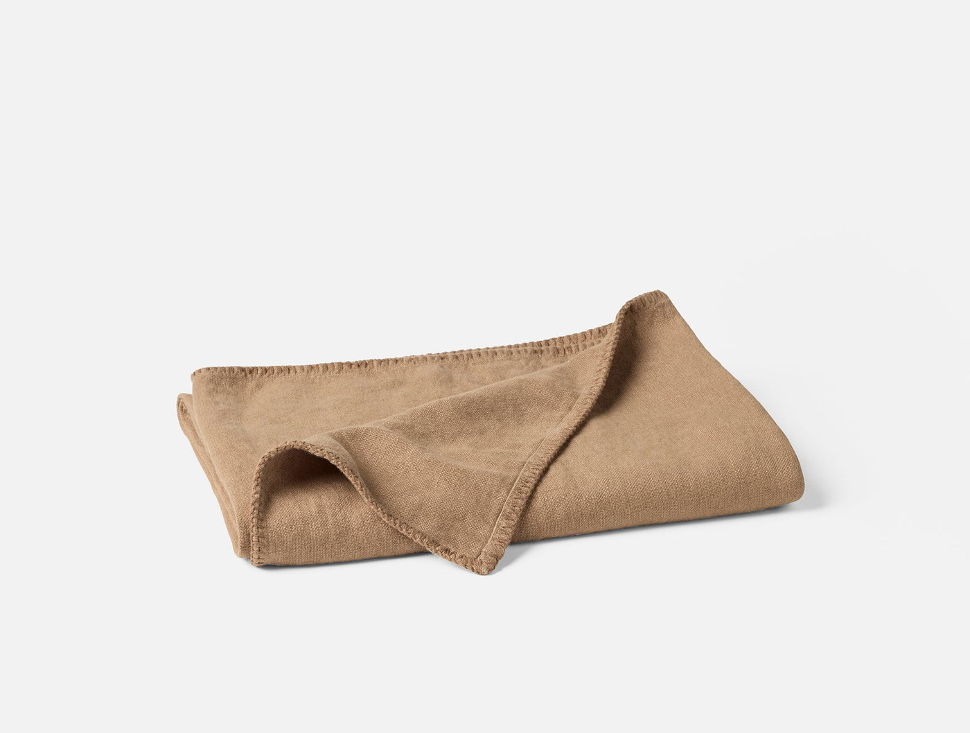 Coyuchi Helena camel linen throw, folded to show blanket stitch edge detail.