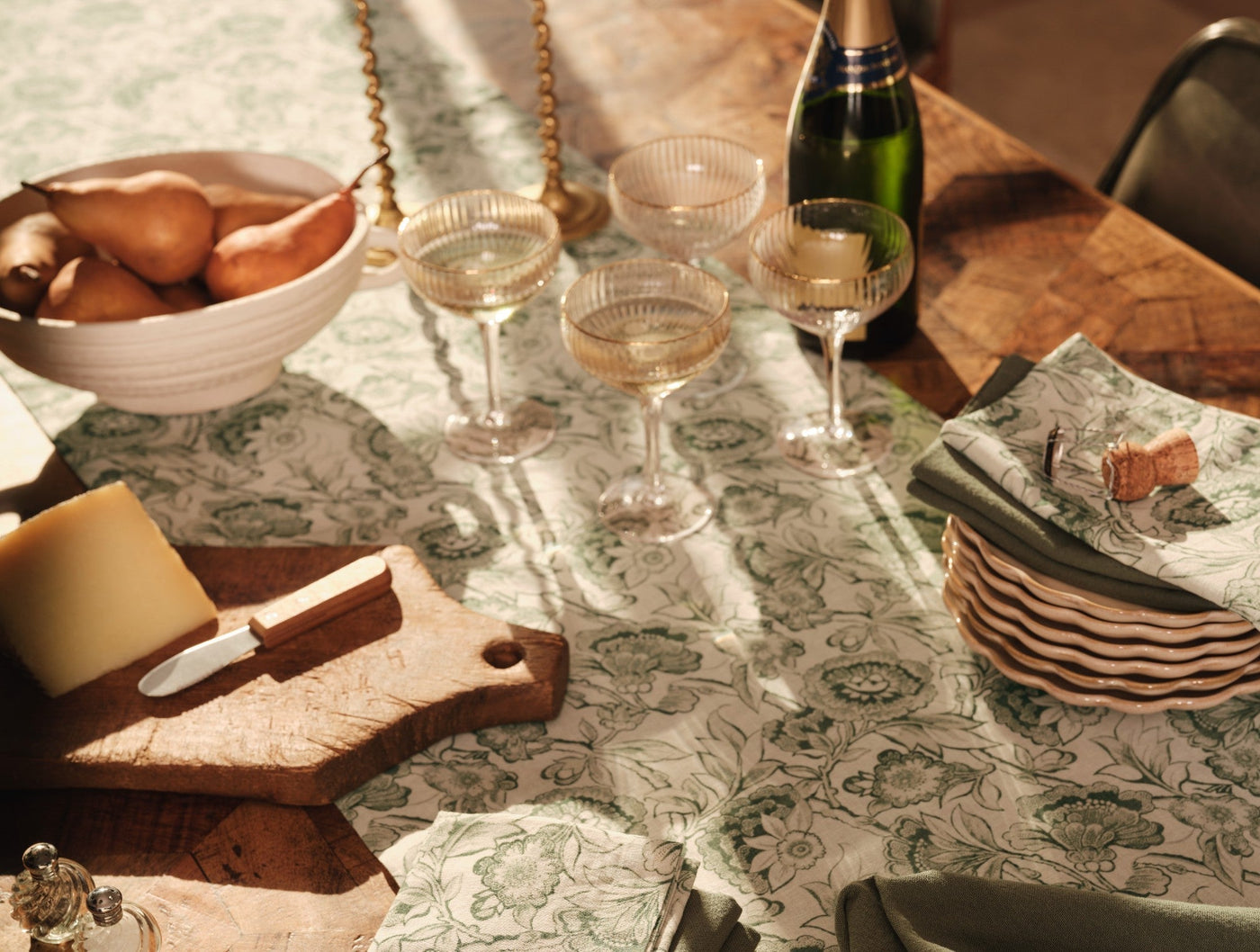 Coyuchi Balboa Print runner styled on dining table with champagne glasses and charcuterie board.