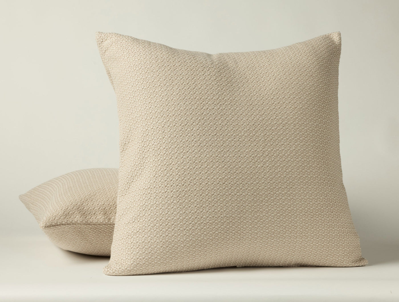 Close-up of Coyuchi Honeycomb sham in natural, showing textured weave pattern on two stacked shams.