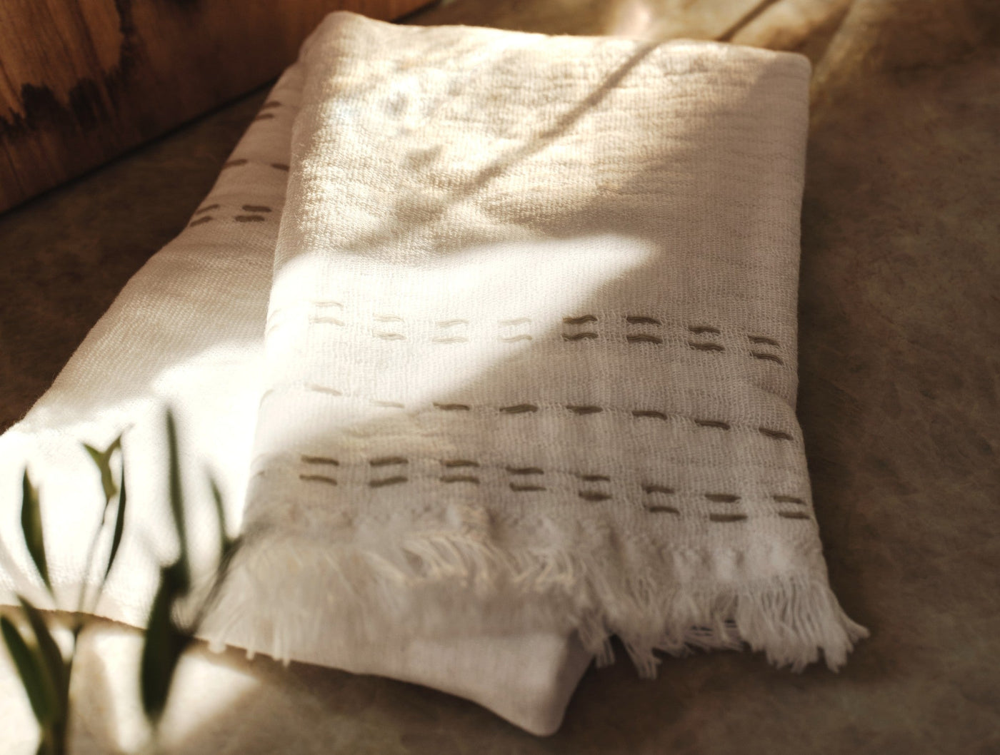 Coyuchi Alder hand towels in ivory, showing fringe hem and woven dash pattern detail.