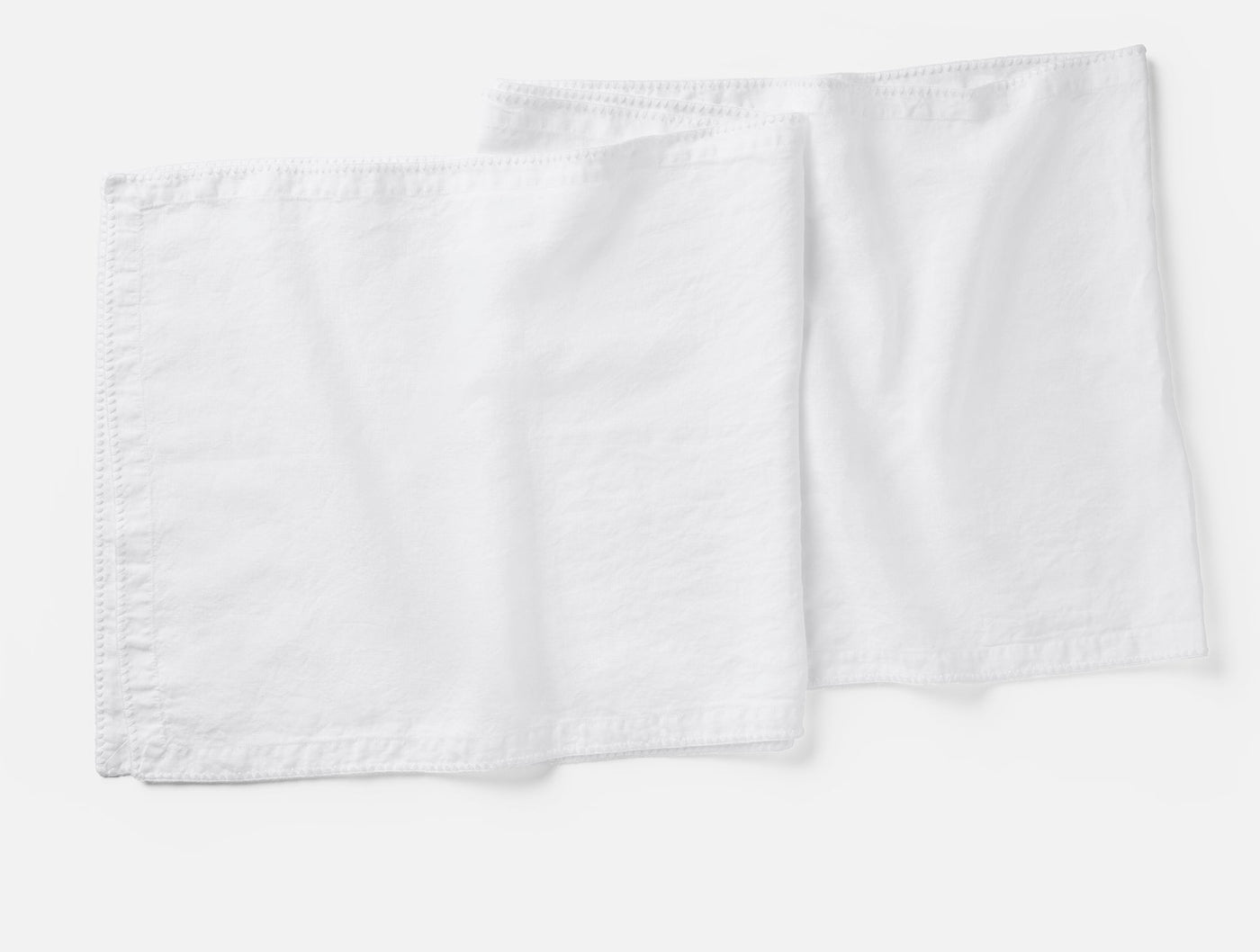 Coyuchi Olivos Embroidered Linen table runner in white, pair shown flat.