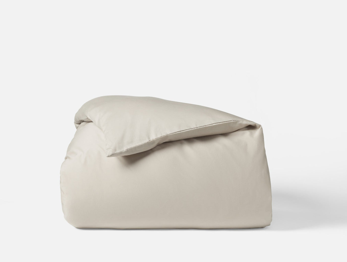 Ivory sateen duvet cover folded and stacked, showing smooth matte finish.