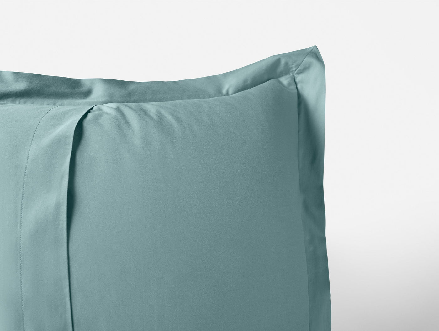 Close-up of Coyuchi Cloud Soft Sateen pillowcase corner in seafoam, showing flange border detail.