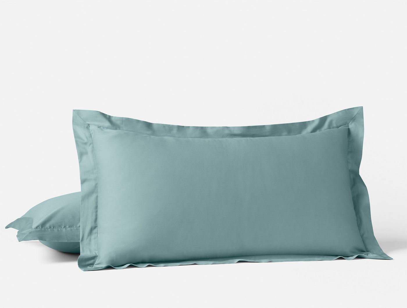Two stacked spa blue sateen pillowcases with tailored flange borders against white background.