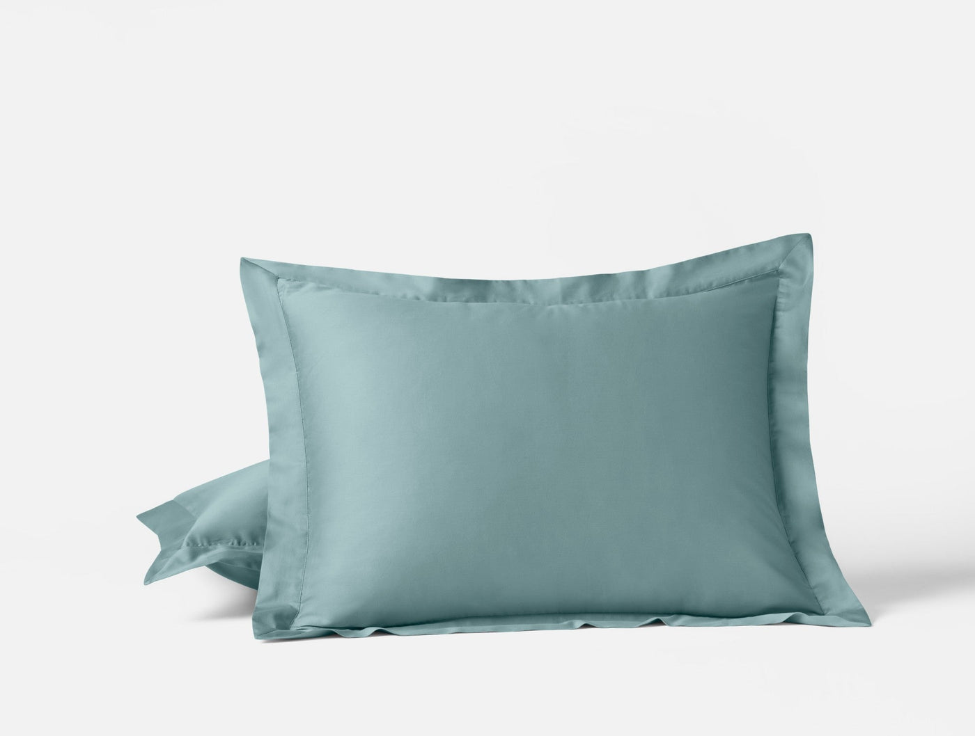 Two Coyuchi Cloud Soft Sateen pillowcases in seafoam, stacked, showing tailored flange border detail.