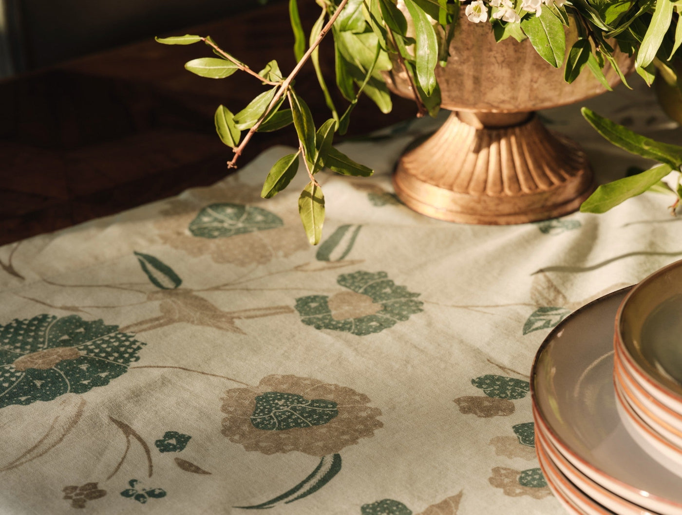 Close-up of Coyuchi Aurora Print runner showing teal and taupe floral motifs on natural linen.