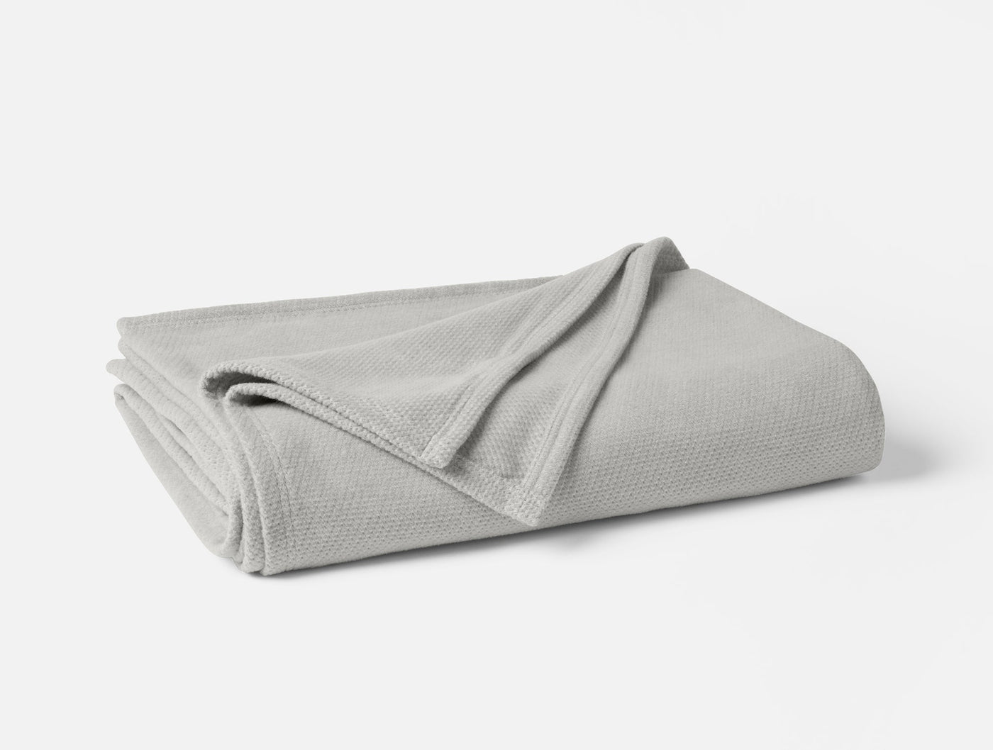 Coyuchi Sequoia blanket folded, showing silver grey waffle-weave texture and trim detail.