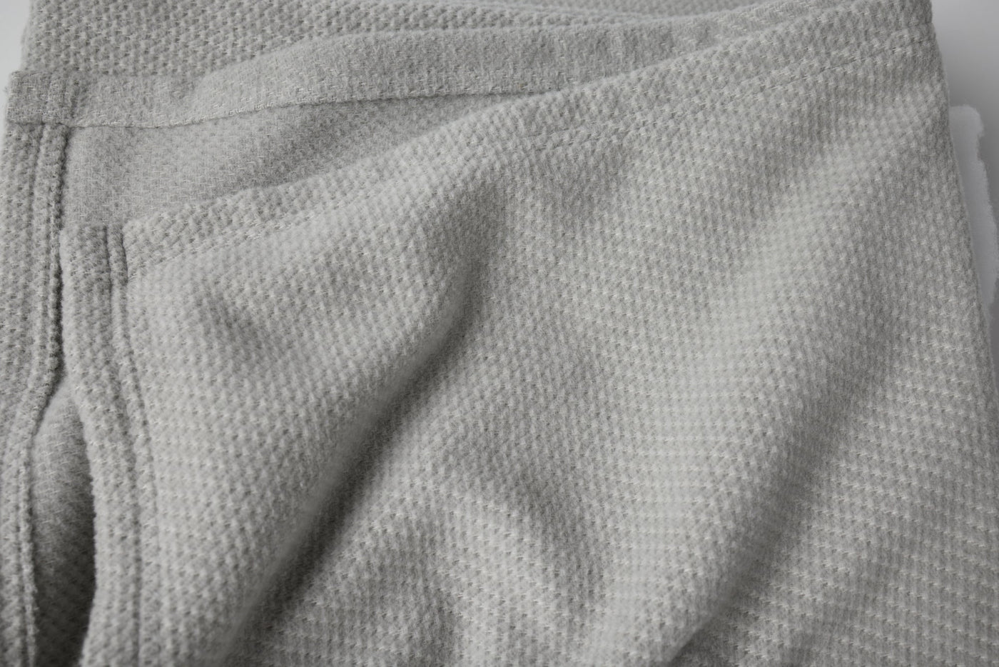 Close-up of Coyuchi Sequoia throw in silver grey, showing waffle-knit texture and folded edge.