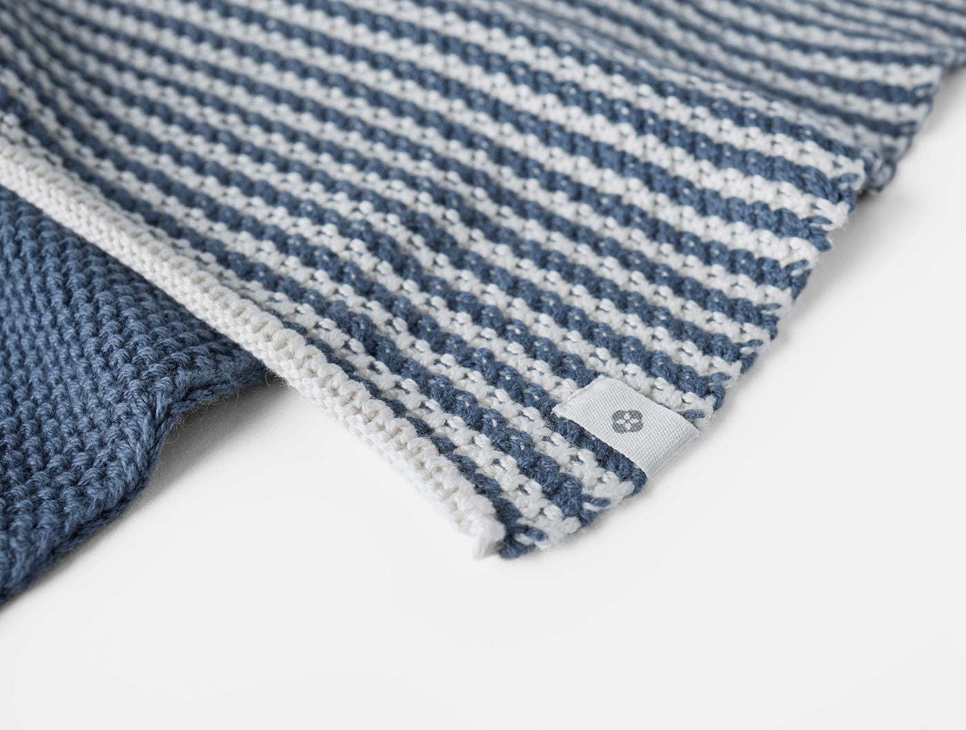 Close-up of Coyuchi Shasta dish cloth corner, showing slate blue and white stripe weave texture.