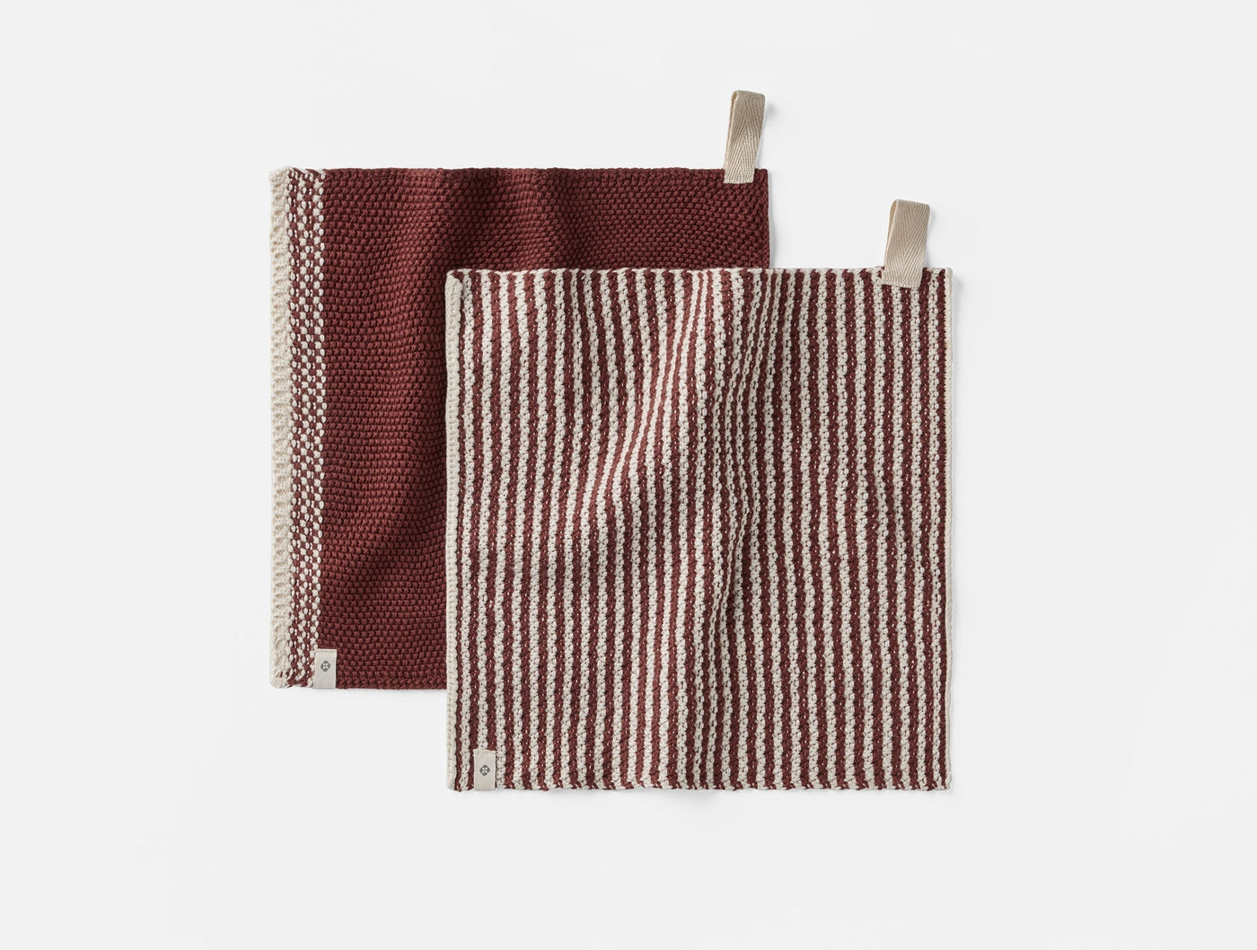 Coyuchi Shasta dish cloths in burgundy stripe and solid, showing both cloth loop tabs.