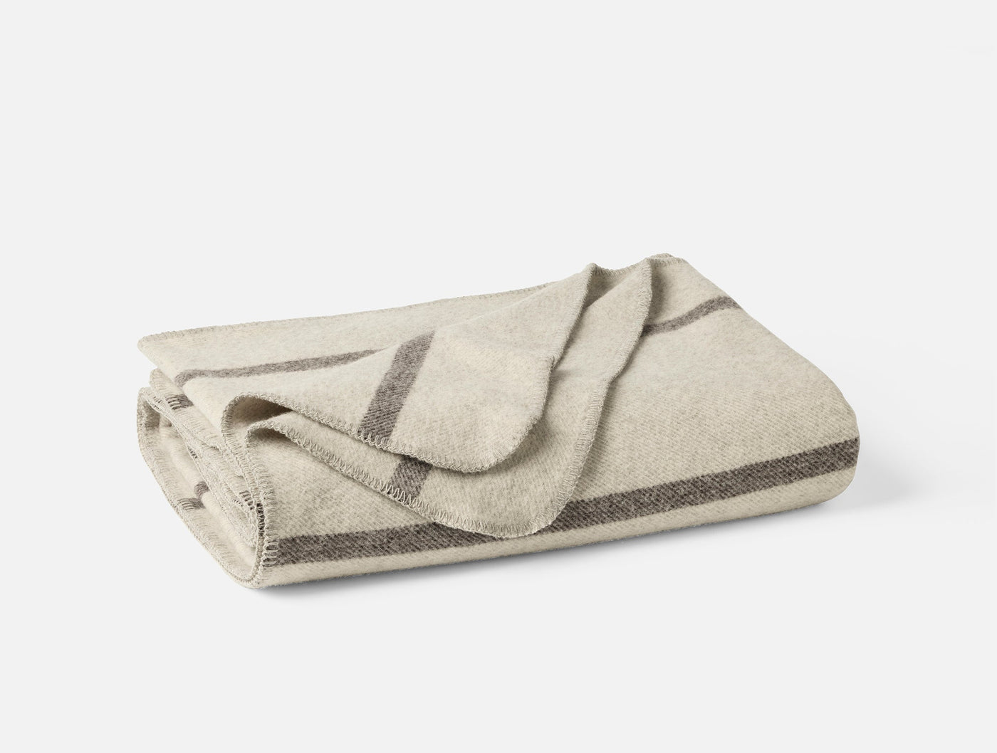 Close-up of folded ivory wool throw with charcoal stripe detailing along edges.