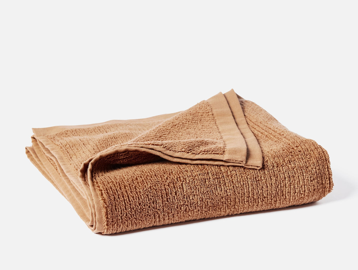 Coyuchi Temescal hand towel folded, showing ribbed cotton texture in warm camel.