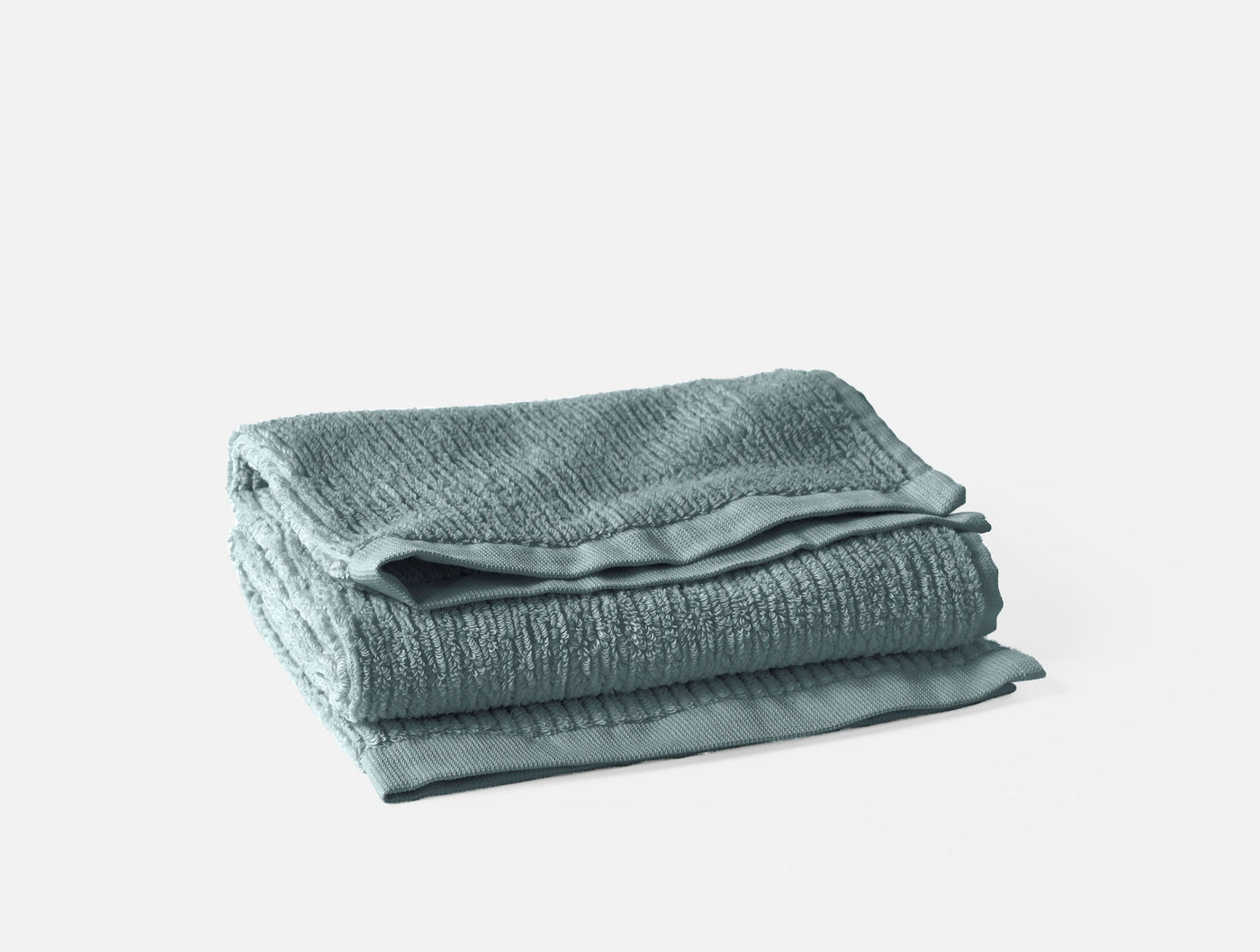 Coyuchi Temescal Ribbed towel set folded in seafoam, showing ribbed texture and satin hem.