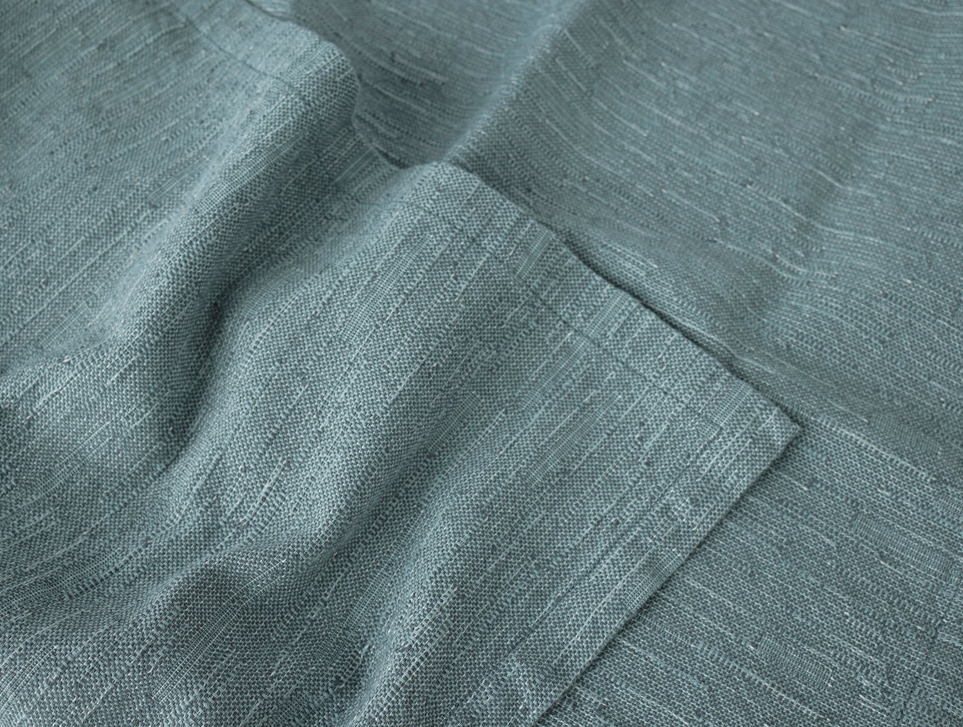 Close-up of Coyuchi Toro Canyon napkin hem detail in slate blue linen weave.