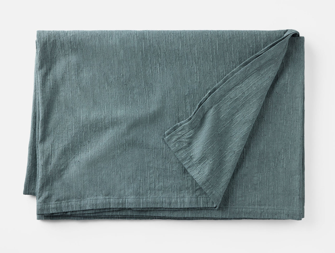 Corner fold detail of Coyuchi Toro Canyon tablecloth in slate blue linen.