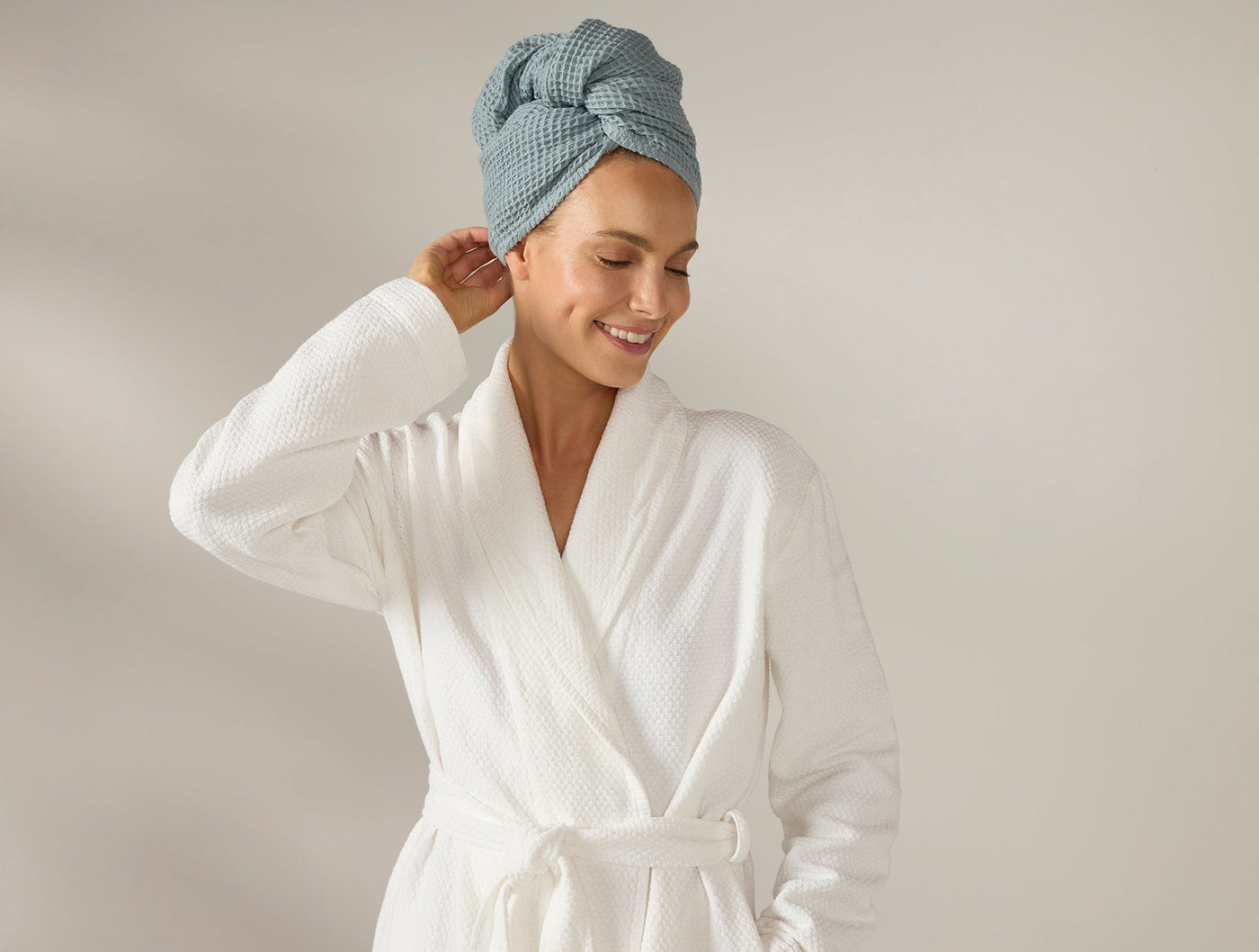 Coyuchi Waffle Hair Wrap in sage blue, worn as turban wrap with white waffle robe.