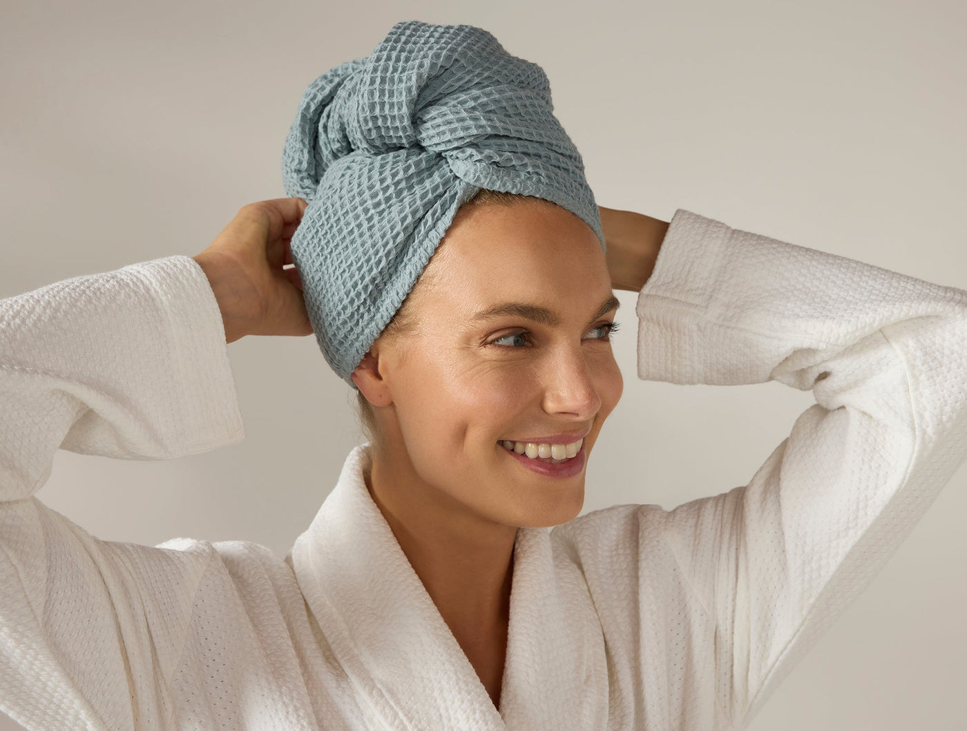 Coyuchi Waffle Hair Wrap in sage blue, worn twisted on head, paired with white waffle robe.