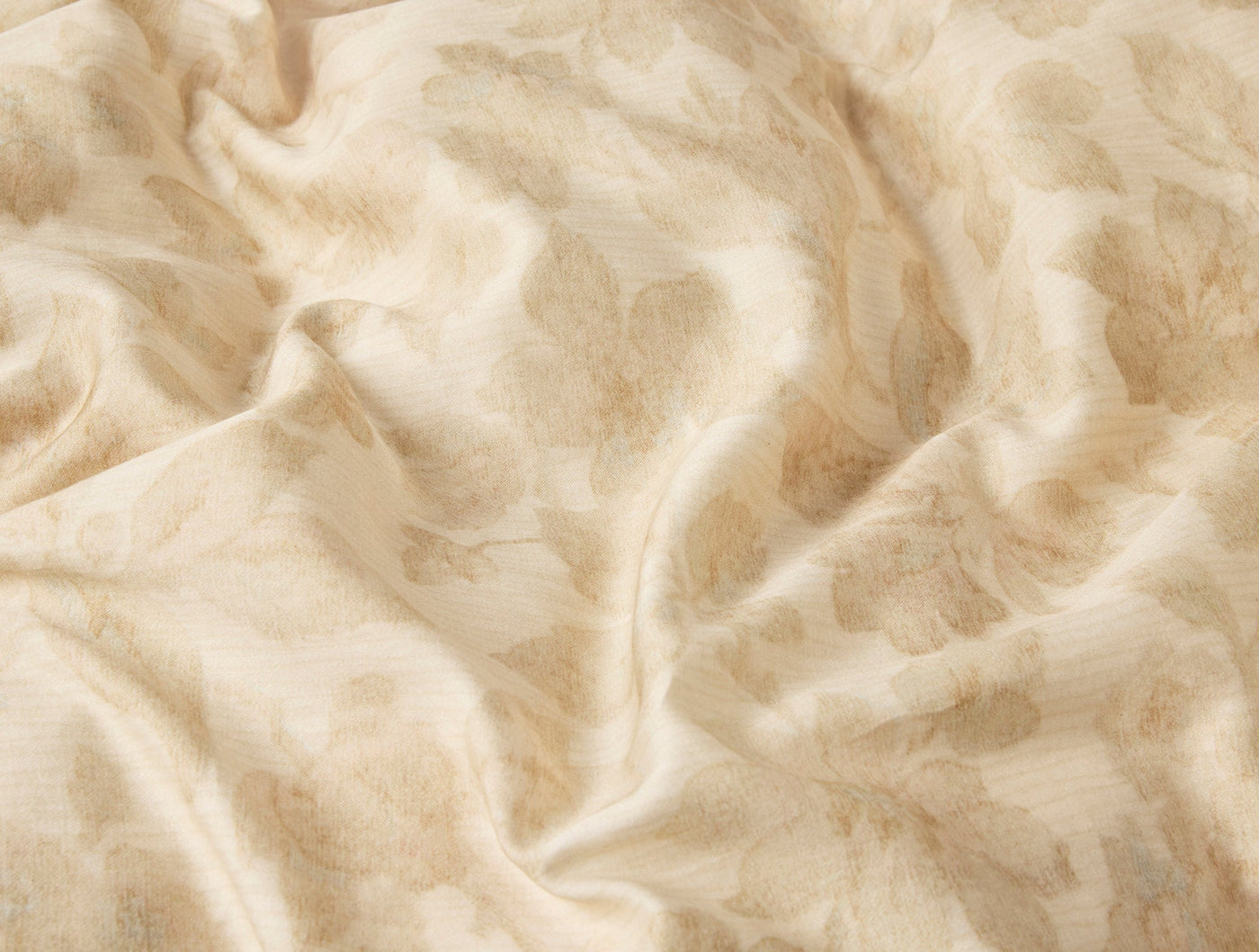 Close-up of Coyuchi Camellia Print duvet cover in ivory with subtle floral jacquard texture.