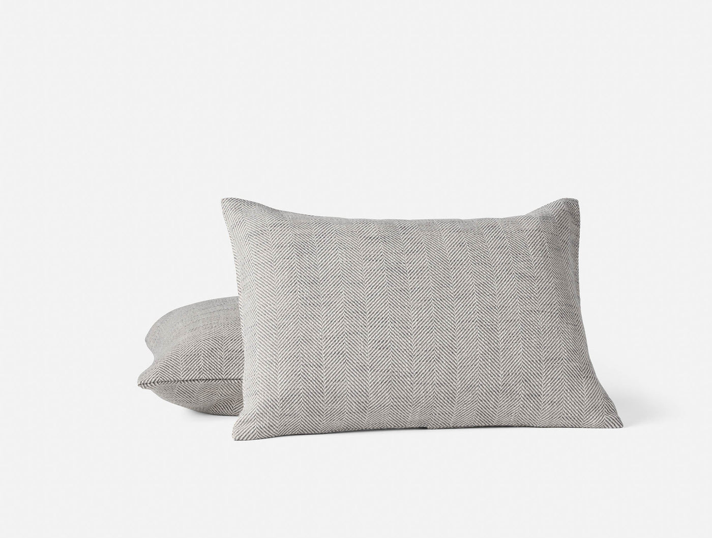 Two Coyuchi Canyon pillow covers stacked, heathered grey woven texture visible.