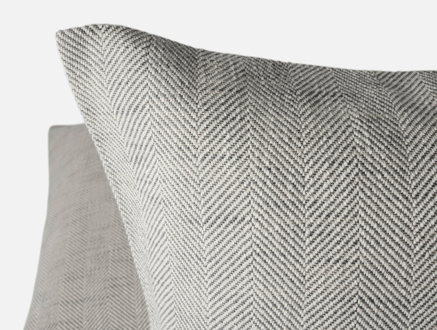 Close-up of Coyuchi Canyon pillow's grey herringbone weave texture and corner detail.