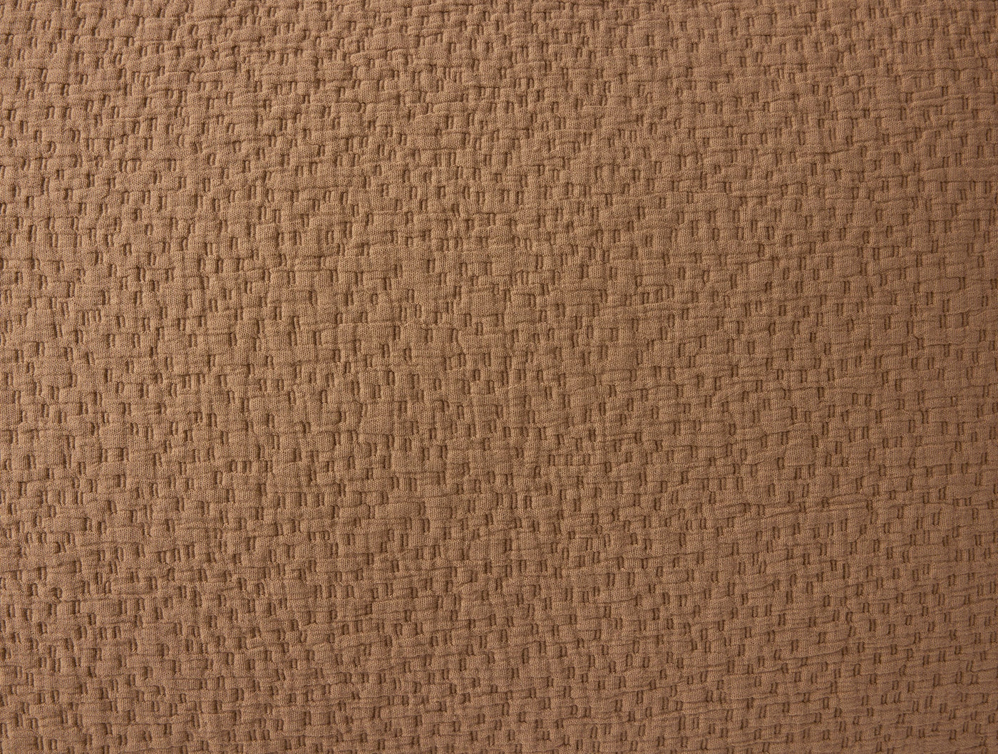Close-up of Coyuchi Cascade Matelasse sham in caramel, showing woven texture detail.