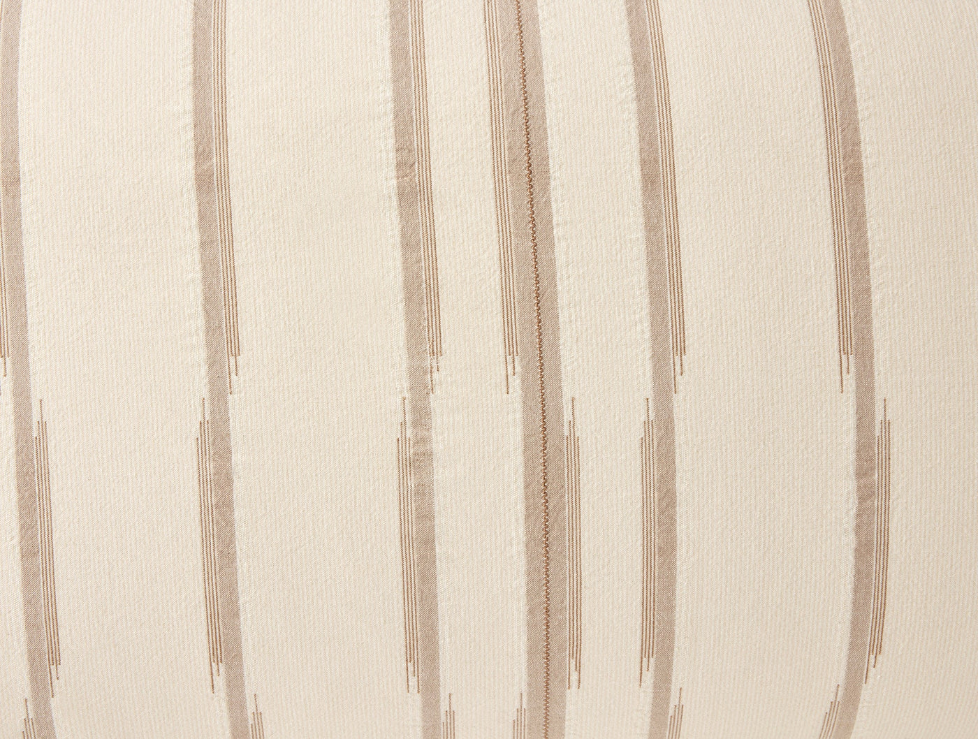 Close-up of Cazadero Stripe sham fabric showing taupe brushstroke stripes on ivory cotton.