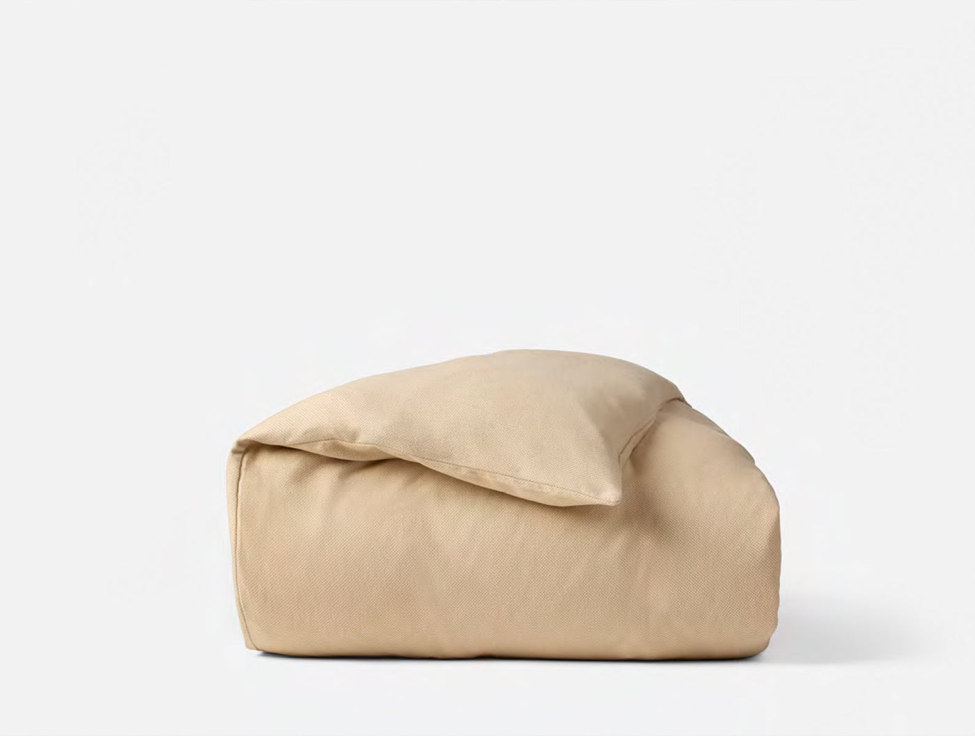 Coyuchi Cloud Brushed Flannel duvet cover folded in warm sand with pillow tucked inside.